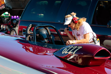 WOODBURN, OR - SEPTEMBER 27, 2015: Dragster driver and pit crew chief going over last minute adjustments before a race at the NHRA 30th Annual Fall Classic at the Woodburn Dragstrip.のeditorial素材