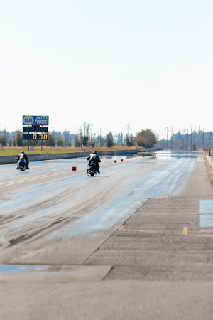 WOODBURN, OR - SEPTEMBER 27, 2015: Two motorcycles racing down the track at the NHRA 30th Annual Fall Classic at the Woodburn Dragstrip.のeditorial素材