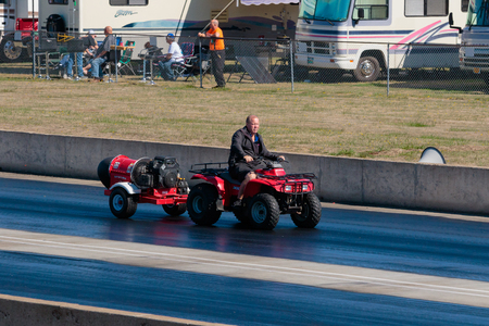 WOODBURN, OR - SEPTEMBER 27, 2015: Track worker drives an ATV with a drying machine on the back to dry the race surface at the NHRA 30th Annual Fall Classic at the Woodburn Dragstrip.のeditorial素材