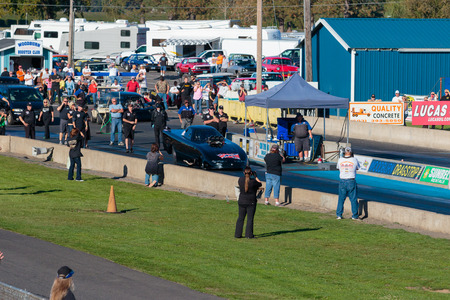 WOODBURN, OR - SEPTEMBER 27, 2015: Spectators and NHRA officials watch the starting line for a licensing run at the NHRA 30th Annual Fall Classic at the Woodburn Dragstrip.のeditorial素材