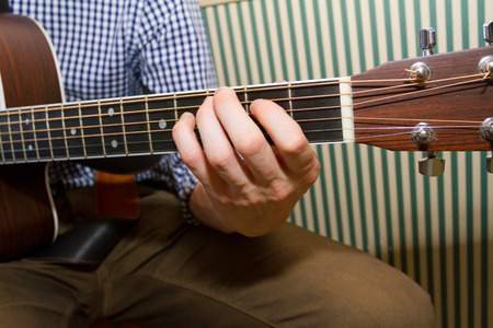 Guitarist strums his guitar on a wedding day playing music for the ceremony.