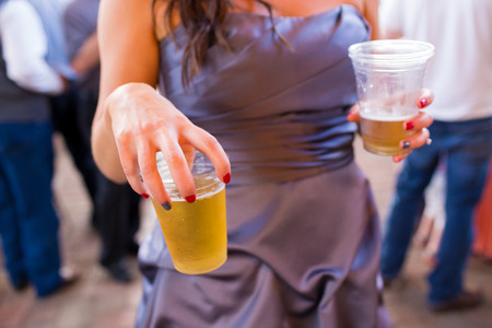 Light beer in a plastic cup at a wedding reception party.