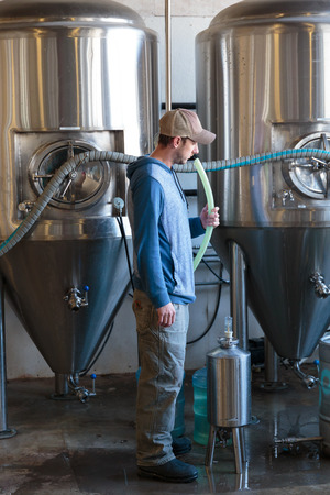 EUGENE, OR - NOVEMBER 4, 2015: Brewery owner Wes Gunderson brewing an IPA at the startup craft...
