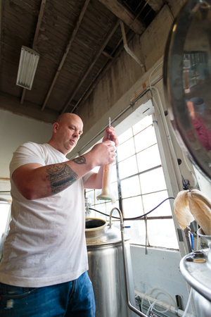 EUGENE, OR - NOVEMBER 4, 2015: Head brewmaster Brandon Woodruff brewing an IPA at the startup craft...