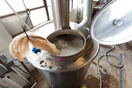 EUGENE, OR - NOVEMBER 4, 2015: Boiling all grain mash to create wort in the commercial brewing...