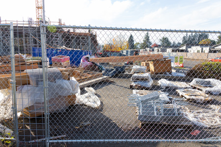 EUGENE, OR - NOVEMBER 4, 2015: Fenced off construction site with ample building materials and...