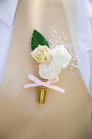 Rifle bullet cartridge with a flower attached to a groom at a wedding ceremony.