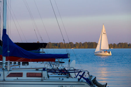 EUGENE, OR - AUGUST 16, 2014: Sailboat sailing across Fern Ridge Reservoir at sunset.のeditorial素材