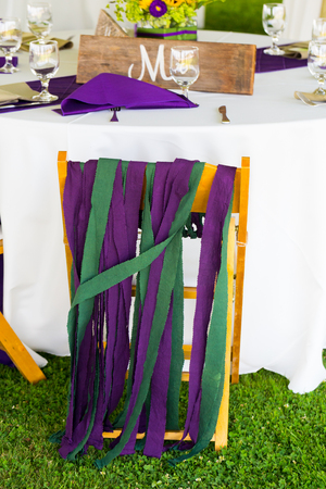 Wedding reception chair decorated for the groom at a dinner table.の写真素材