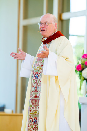 TUALATIN, OR - OCTOBER 4, 2014: Catholic priest in traditional robe speaking to a congregation at Resurrection Catholic Parrish.のeditorial素材