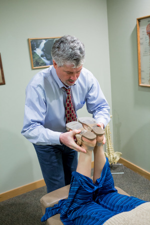 SPRINGFIELD, OR - AUGUST 20, 2014: Chiropractor adjusting the spine of an adult woman in a medical patient room.のeditorial素材