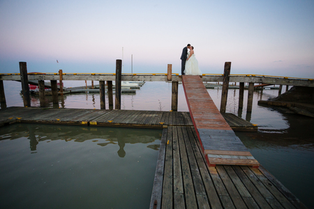 Portrait of a bride and groom on their wedding day at a yacht club marina in Oregon.の写真素材