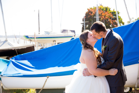 Portrait of a bride and groom on their wedding day at a yacht club marina in Oregon.の写真素材
