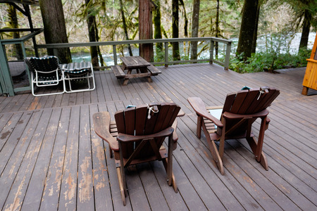 Screen room at a vacation cabin next to a large deck with adirondack chairs of wood.の写真素材
