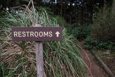 Restrooms sign with an arrow points toward a nature trail that leads to the bathroom at a campground in Oregon.の写真素材