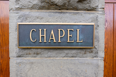 Wood doors and a sign that says chapel at a very old historic church in an urban setting.の写真素材