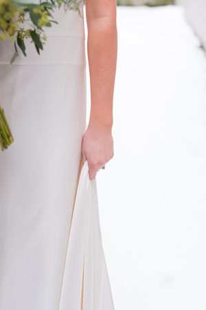 Bride holding her dress up at a snowy winter wedding in Oregon.の写真素材