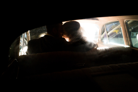 Bride and Groom Kissing in Carの写真素材