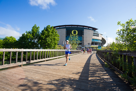 EUGENE, OR - MAY 7, 2017: Runners race in front of Autzen Stadium at mile 16 of the 2017 Eugene Marathon race held on the University of Oregon campus.のeditorial素材