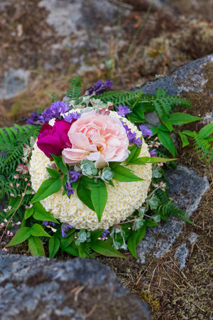 Wedding cake on river rock with native species plants and flowers at a North Umpqua River elopement...