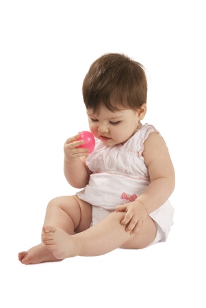 This is a little baby girl playing Easter eggs hunt isolated over a white background.の写真素材