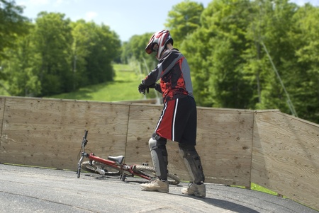This is a guy fixing is equipment to ride a mountain bike.の写真素材