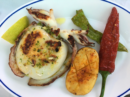 Octopus, green and red peppers, cooked on a griddle, a typical dish available in a Spanish tapas...