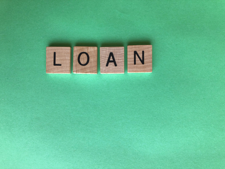 Banking  and Finance, creative concept. Wooden letters spelling the word Loan on a plain green background with copy spaceの写真素材