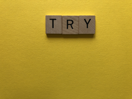 Motivational Words : Try in 3d wooden alphabet letters on a bright yellow background with copy spaceの写真素材