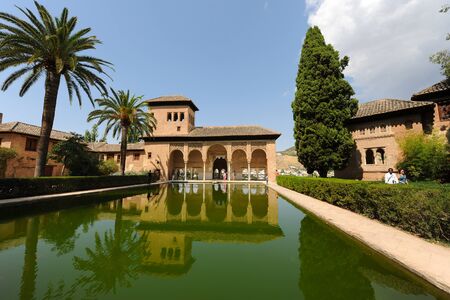 Pond reflections and visitors at the open portico of Torre de las Damas, Tower of The Ladies, Partal, The Alhambra, Granada, Andalusia, Spainのeditorial素材