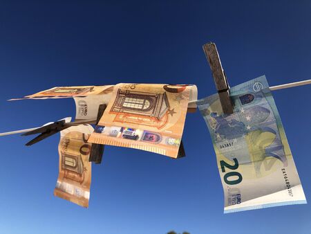 Creative Concept, money laundering. Euro banknotes pegged on a washing line to dry, blowing in the...