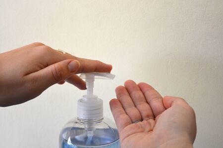 Girl using hand sanitiser from a gel pump, with instructions for use