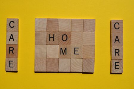 Care, Home, words in wooden alphabet letters on yellow backgroundの写真素材