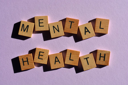 Mental Health, words in wooden alphabet letters isolated on purple backgroundの写真素材