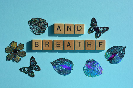 And Breathe, words in wooden alphabet letters framed by flower, butterfly and leaf shapes, isolated...