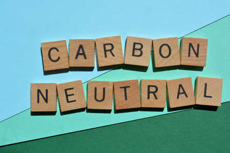 Carbon Neutral, words in wooden alphabet letters isolated on green and blue background