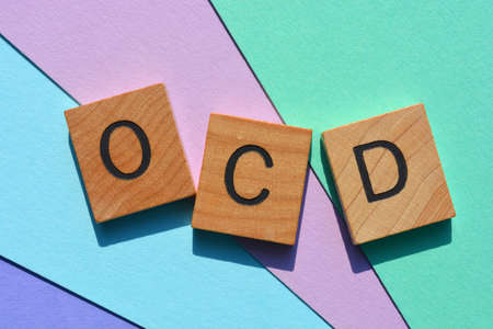 OCD acronym for Obsessive Compulsive Disorder in wooden alphabet letters on colourful backgroundの写真素材
