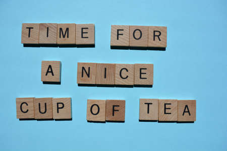 Time For a Nice Cup of Tea, phrase in wooden alphabet letters isolated on blue background