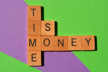 Time Is Money, words in wooden alphabet letters isolated on backgroundの写真素材