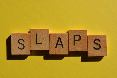 Slaps. word in wooden alphabet letters, Generation Z slang used to describe how great something is