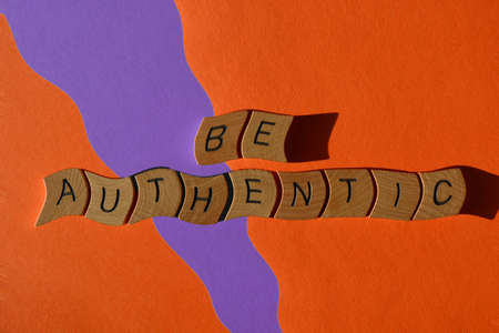 Be Authentic, words in wooden alphabet letters isolated on orange and purple background