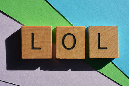 LOL acronym for Laughing Out Loud, in wooden alphabet letters isolated on colourful background