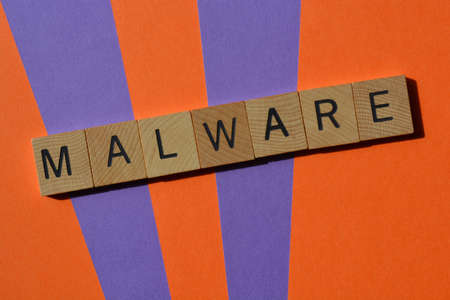 Malware, word in wooden alphabet letters isolated on background as banner headline with copy spaceの写真素材