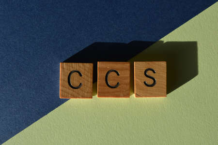 CCS, acronym for Carbon Capture Storage, in wooden alphabet letters isolated on blue and green backgroundの写真素材