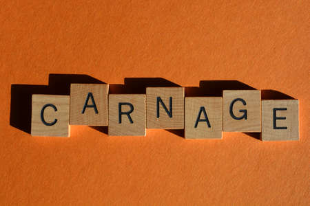 Carnage, word in wooden alphabet letters isolated on orange background as banner headlineの写真素材
