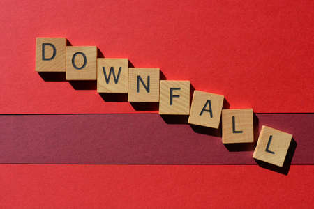 Downfall, word in wooden alphabet letters isolated on red backgroundの写真素材