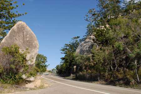 The road on Magnetic Island, with granite boulders, Hoop pines and eucalyptus trees, Queensland, Australiaの写真素材