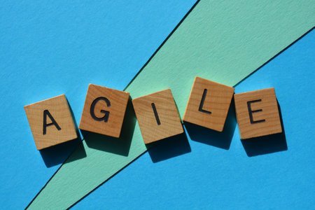 Agile, word in wooden alphabet letters isolated on blue background