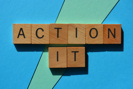 Action It, words in wooden alphabet letters isolated on blue backgroundの写真素材