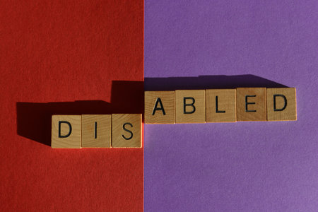Disabled, word in wooden alphabet letters, split in to Dis and Abled, isolated on backgroundの写真素材